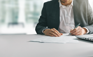 Financial professional writing on a desk